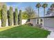 Well-maintained backyard with lush green grass, manicured landscaping, mature trees, offering a serene outdoor space at 345 W Gardenia Dr, Phoenix, AZ 85021