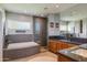 Modern bathroom featuring a large soaking tub, a glass-enclosed shower, and dual sinks at 345 W Gardenia Dr, Phoenix, AZ 85021