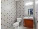 A well-appointed half bath features stylish wallpaper, modern fixtures, and a sleek vanity at 345 W Gardenia Dr, Phoenix, AZ 85021