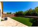 Expansive backyard with manicured artificial turf, travertine patio, and a comfortable fire pit area at 3899 S Chaparral Rd, Apache Junction, AZ 85119