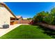 Spacious backyard featuring lush artificial turf, a built-in grill, and a cozy fire pit area at 3899 S Chaparral Rd, Apache Junction, AZ 85119