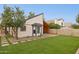 A backyard featuring grass, rock landscaping, an open patio and a covered parking area at 3948 W Butler St, Chandler, AZ 85226