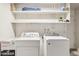 Functional laundry room featuring a washer, a dryer and shelving units at 3948 W Butler St, Chandler, AZ 85226