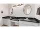 Double vanity with round mirrors in a brightly lit bathroom; clean design at 448 E Wescott Dr, Phoenix, AZ 85024
