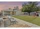Private backyard featuring green grass, mature trees, seating, and a covered patio at 4938 W Tuckey Ln, Glendale, AZ 85301