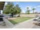 Spacious backyard with a lush green lawn, mature trees, playground, and shed at 4938 W Tuckey Ln, Glendale, AZ 85301