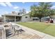 Private backyard featuring green grass, mature trees, seating, and a covered patio at 4938 W Tuckey Ln, Glendale, AZ 85301