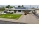 Well-maintained single-story home featuring green lawn, solar panels, and a convenient extended driveway at 4938 W Tuckey Ln, Glendale, AZ 85301
