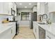 Bright kitchen features quartz counters, stainless appliances, and light wood-look tile flooring at 4938 W Tuckey Ln, Glendale, AZ 85301