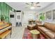 Bright and airy living room features wood-look tile flooring, vintage piano, and comfortable leather seating at 4938 W Tuckey Ln, Glendale, AZ 85301