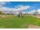 The backyard features a well-maintained lawn and play structure at 5038 W Acoma Dr, Glendale, AZ 85306