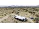 Expansive aerial view of the property, including home, outbuildings, and desert landscaping against a mountain backdrop at 50525 W Whirly Bird Rd, Maricopa, AZ 85139