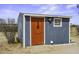 A small outbuilding with a unique guitar door design, window, and neutral paint, blending into the desert landscape at 50525 W Whirly Bird Rd, Maricopa, AZ 85139