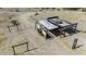 Aerial view showcasing the land, structures, and surrounding arid landscape of the property at 50525 W Whirly Bird Rd, Maricopa, AZ 85139