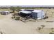 Home featuring solar panels, outbuilding, fenced yard, and natural desert surroundings at 50525 W Whirly Bird Rd, Maricopa, AZ 85139