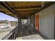 Inviting covered front porch featuring wooden decking and providing ample space for outdoor seating at 50525 W Whirly Bird Rd, Maricopa, AZ 85139