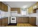 Kitchen with wood cabinets, white appliances, and natural light at 50525 W Whirly Bird Rd, Maricopa, AZ 85139