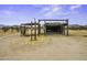 Property featuring a rustic, open-sided outbuilding in a desert landscape at 50525 W Whirly Bird Rd, Maricopa, AZ 85139