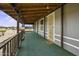 Inviting covered porch with green carpet, wooden railing and door at 50525 W Whirly Bird Rd, Maricopa, AZ 85139