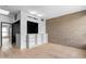 Spacious living room features hardwood floors, a concrete accent wall, and built-in shelving, providing ample storage and style at 525 E Willetta St # 2, Phoenix, AZ 85004