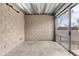 A neutral room with an exposed block wall and a sliding glass door at 525 E Willetta St # 2, Phoenix, AZ 85004