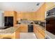 Kitchen features stainless steel appliances, granite countertops, wooden cabinetry, and an island cooktop at 5970 N Echo Canyon Dr, Phoenix, AZ 85018