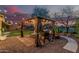 Landscaped backyard with a covered pergola, grill, seating, and string lights at 6804 S 45Th Gln, Laveen, AZ 85339