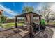 Charming backyard gazebo with comfortable seating and a grill, set against a backdrop of a lush green lawn at 6804 S 45Th Gln, Laveen, AZ 85339