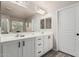 Bathroom featuring a double sink vanity with modern fixtures, a large mirror, and white cabinets at 6804 S 45Th Gln, Laveen, AZ 85339
