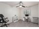 Bright bedroom with a ceiling fan, a desk next to the window, and gray carpet at 6804 S 45Th Gln, Laveen, AZ 85339