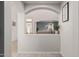 Open entryway with arched openings, leading to a living room and dining area with neutral color palette at 6804 S 45Th Gln, Laveen, AZ 85339