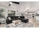 Open-concept living room leading to a kitchen, featuring a modern sofa and tile flooring at 6804 S 45Th Gln, Laveen, AZ 85339