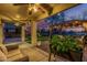 Covered patio with cozy seating, string lights, and a view of the landscaped backyard at 6804 S 45Th Gln, Laveen, AZ 85339