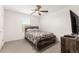 Bedroom with carpeted floors, a ceiling fan, and a wood frame bed with a decorative comforter at 6823 W Getty Dr, Phoenix, AZ 85043