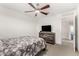 Cozy bedroom features a ceiling fan and rustic wood dresser with a television at 6823 W Getty Dr, Phoenix, AZ 85043