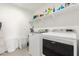 Laundry room featuring modern appliances, storage shelves, and plenty of space at 6823 W Getty Dr, Phoenix, AZ 85043