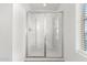 Modern shower featuring glass doors, built-in shelving, and a clean design at 6823 W Getty Dr, Phoenix, AZ 85043