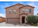 Two-story home featuring a two-car garage, neutral colored stucco, and a covered front porch at 6925 W Maldonado Rd, Laveen, AZ 85339