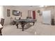Open concept living area with tile flooring, a pool table, and access to the front entrance at 6925 W Maldonado Rd, Laveen, AZ 85339