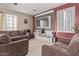 Living area featuring tile flooring, a TV, two sofas and a custom wood accent wall at 6925 W Maldonado Rd, Laveen, AZ 85339