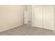 Bedroom with carpet, closet with white paneled doors, and an open door to a bathroom at 6970 W Paso Trl, Peoria, AZ 85383