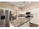 Modern kitchen features stainless steel appliances, granite countertops and white cabinetry at 6970 W Paso Trl, Peoria, AZ 85383