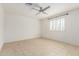 Bright bedroom with tiled floors, ceiling fan, and plantation shutters at 7359 W Rancho Dr, Glendale, AZ 85303