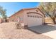 Exterior view showcasing a two-car garage and low-maintenance landscaping at 7359 W Rancho Dr, Glendale, AZ 85303