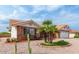 Charming desert home with lush palm trees, vibrant green grass accents, and a red brick exterior at 7859 E Nido Ave, Mesa, AZ 85209