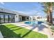 Backyard boasts a pristine pool with spa, travertine decking, a covered patio, lush lawn, and mature palms at 7939 E Via Linda --, Scottsdale, AZ 85258