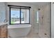 Bright bathroom featuring a soaking tub, walk-in shower, and a large window with natural light at 7939 E Via Linda --, Scottsdale, AZ 85258