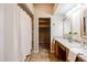 Bright bathroom featuring double sinks and a shower/tub with curtains for privacy plus adjacent walk-in closet at 902 W Glendale Ave # 115, Phoenix, AZ 85021