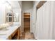 Well-lit bathroom featuring a double vanity, an enclosed shower, and a walk-in closet at 902 W Glendale Ave # 115, Phoenix, AZ 85021