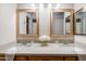 Bright bathroom vanity featuring double sinks, contemporary fixtures, and decorative mirrors at 902 W Glendale Ave # 115, Phoenix, AZ 85021
